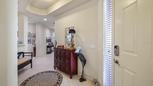 foyer entrance with light tile patterned floors, a tray ceiling, recessed lighting, and baseboards