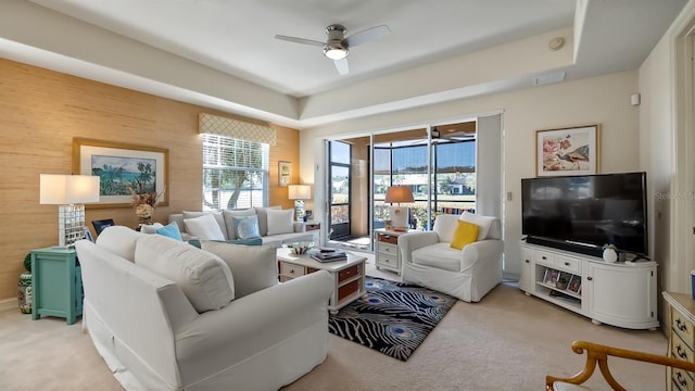 living room with a ceiling fan and light colored carpet