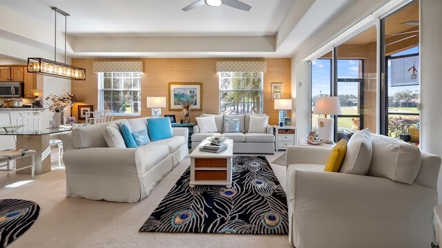 carpeted living area featuring ceiling fan