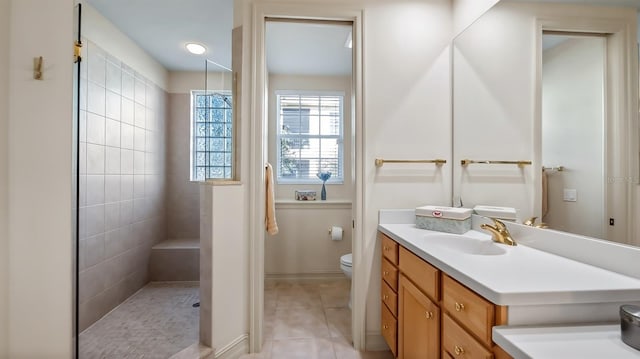 full bathroom with toilet, tile patterned flooring, a walk in shower, and vanity