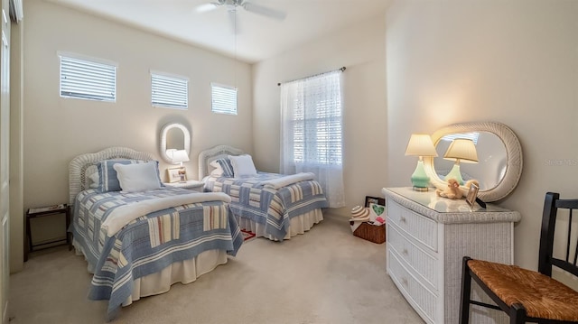 bedroom with light carpet and a ceiling fan