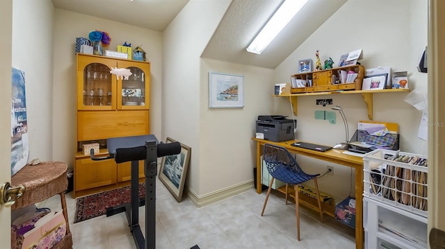 office area featuring lofted ceiling and baseboards