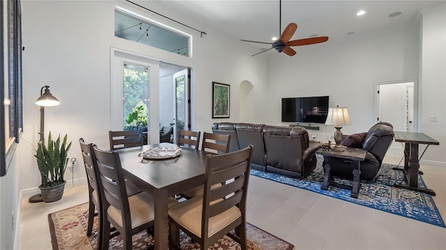 dining area featuring a towering ceiling, ceiling fan, baseboards, and recessed lighting