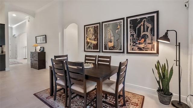 dining room featuring baseboards and arched walkways