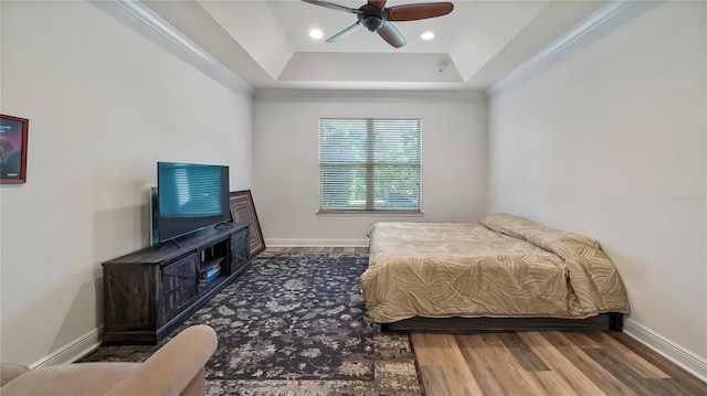 bedroom featuring a tray ceiling, recessed lighting, wood finished floors, and baseboards