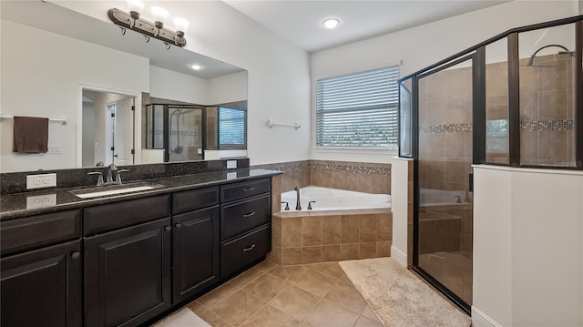 full bathroom featuring a garden tub, a stall shower, tile patterned flooring, and vanity