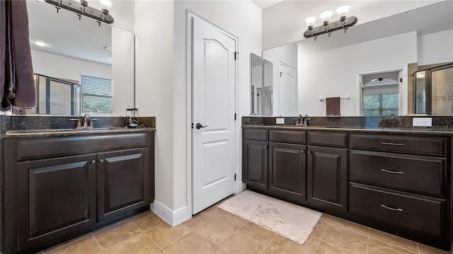 bathroom with a healthy amount of sunlight, two vanities, and a shower stall