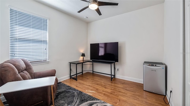 sitting room with light wood finished floors, ceiling fan, and baseboards