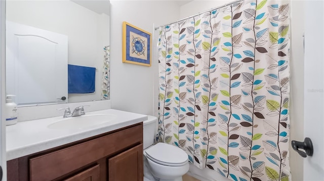 bathroom with toilet, vanity, and a shower with shower curtain