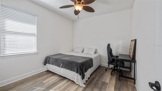 bedroom with a ceiling fan, baseboards, and wood finished floors