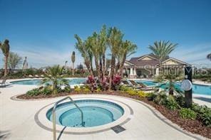 community pool featuring a community hot tub and a patio area