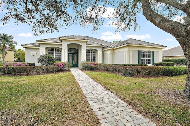 view of front of house with french doors, a front lawn, and stucco siding