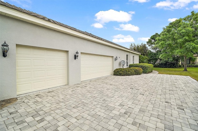 garage with decorative driveway