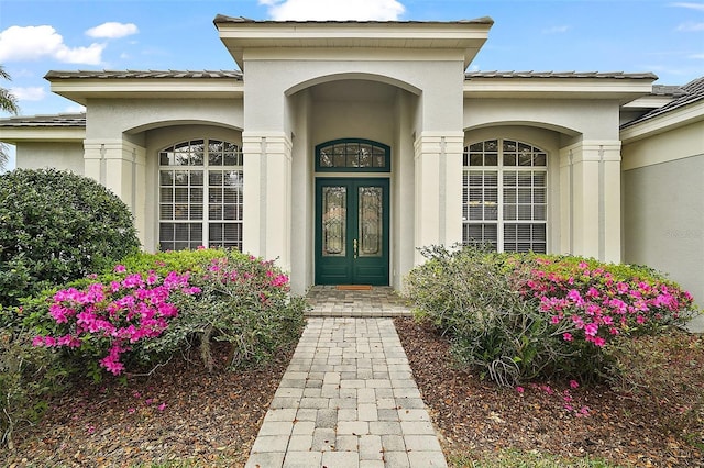 doorway to property featuring french doors and stucco siding