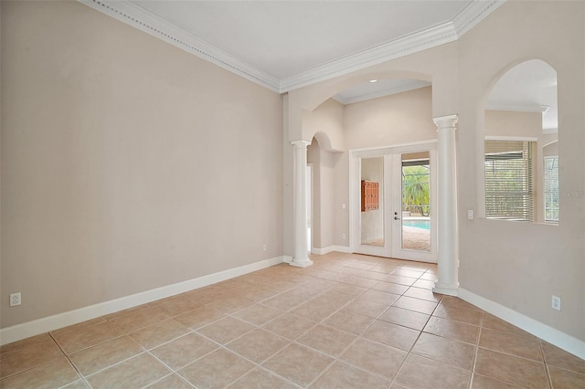 empty room featuring light tile patterned floors, baseboards, decorative columns, and crown molding