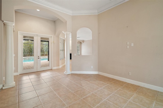 spare room featuring ornate columns, light tile patterned floors, crown molding, and french doors