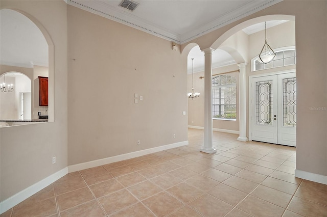 foyer with ornate columns, visible vents, crown molding, and light tile patterned flooring