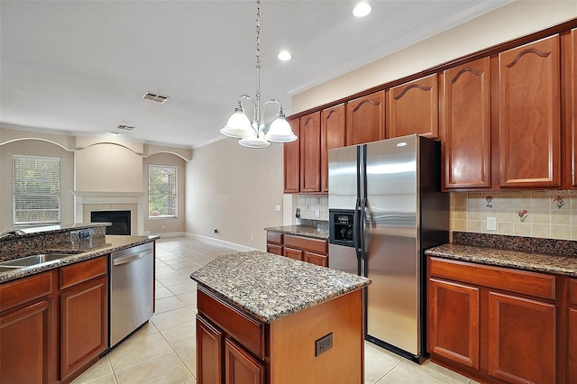 kitchen featuring visible vents, dark stone countertops, stainless steel appliances, a sink, and light tile patterned flooring