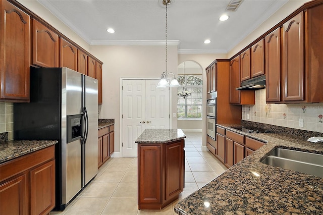 kitchen featuring visible vents, appliances with stainless steel finishes, ornamental molding, a center island, and under cabinet range hood