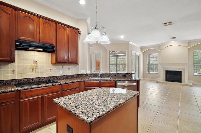 kitchen featuring light tile patterned floors, visible vents, black electric cooktop, under cabinet range hood, and a sink