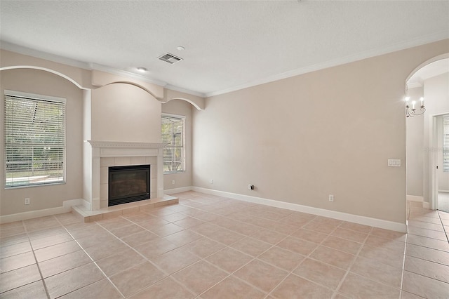 unfurnished living room featuring light tile patterned floors, a fireplace, visible vents, baseboards, and crown molding