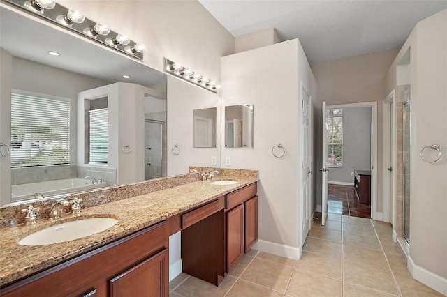 bathroom featuring double vanity, a stall shower, tile patterned flooring, and a sink