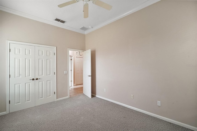 unfurnished bedroom featuring baseboards, crown molding, visible vents, and carpet flooring