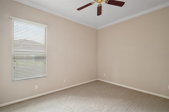 carpeted spare room featuring baseboards, ornamental molding, and a ceiling fan