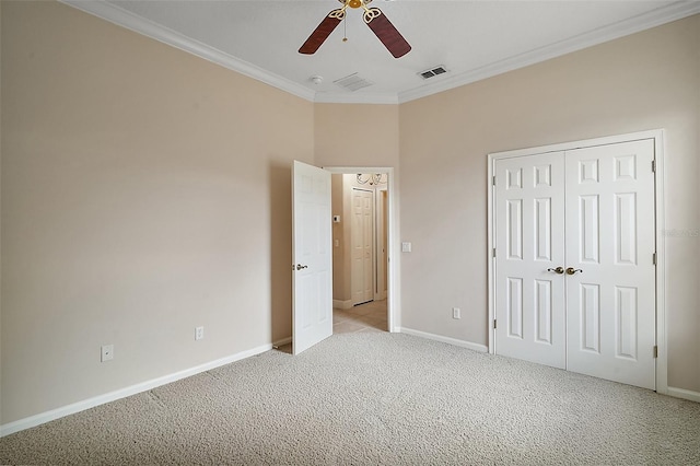 unfurnished bedroom featuring a closet, visible vents, ornamental molding, light carpet, and baseboards