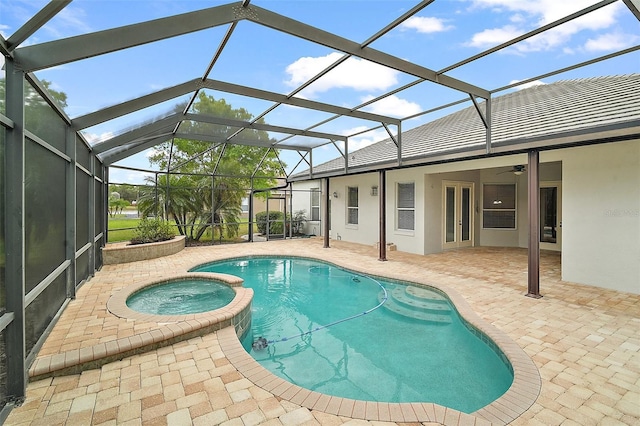 view of pool with a pool with connected hot tub, a patio area, and a lanai