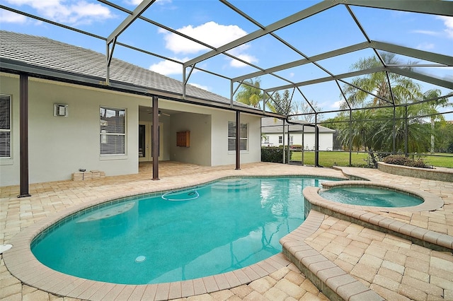 view of swimming pool with a patio, glass enclosure, a pool with connected hot tub, and a ceiling fan