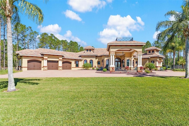 view of front of home with stucco siding, driveway, an attached garage, and a front lawn