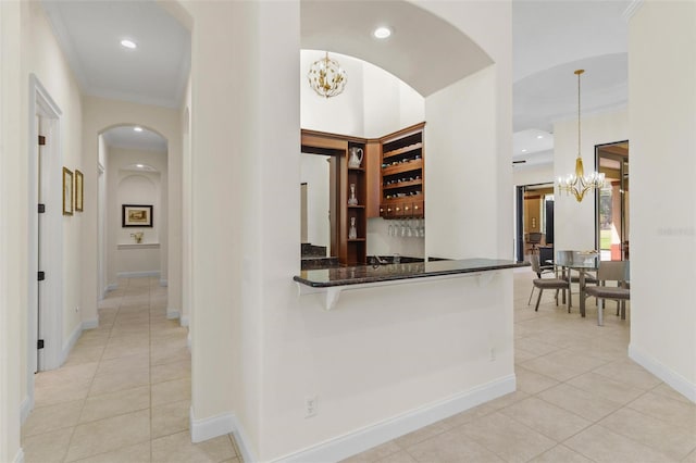 hall featuring light tile patterned floors, recessed lighting, crown molding, and an inviting chandelier