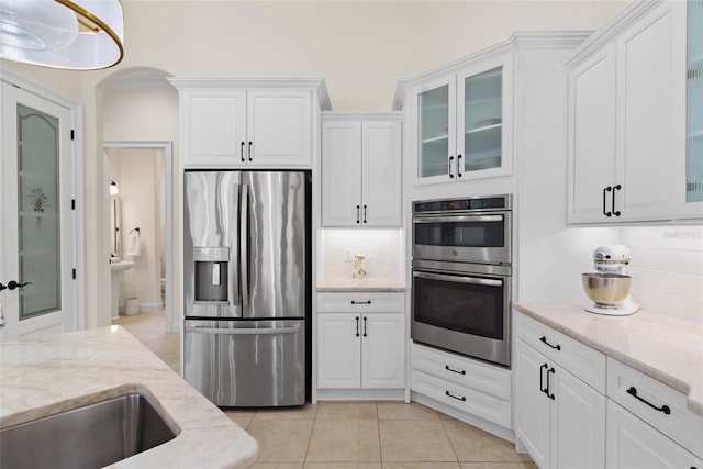 kitchen featuring white cabinets, backsplash, and appliances with stainless steel finishes