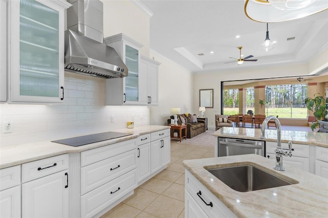 kitchen with crown molding, black electric stovetop, wall chimney range hood, dishwasher, and a tray ceiling