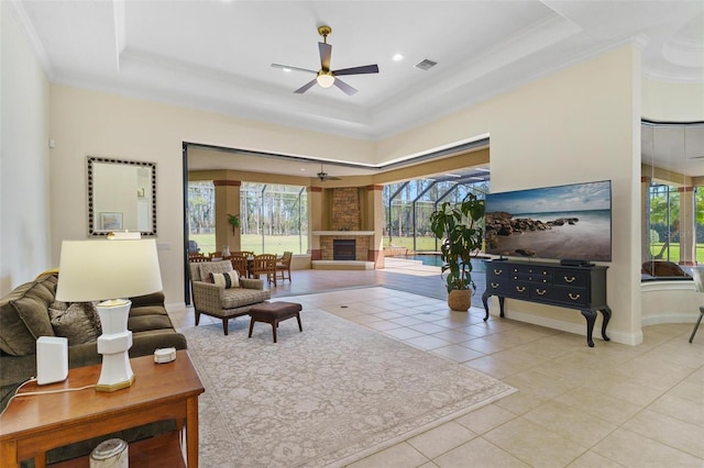 living area with a healthy amount of sunlight, a tray ceiling, and ceiling fan