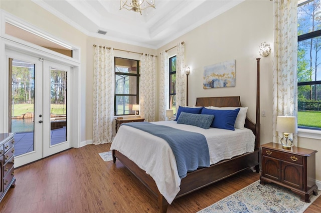 bedroom with access to exterior, wood finished floors, and french doors