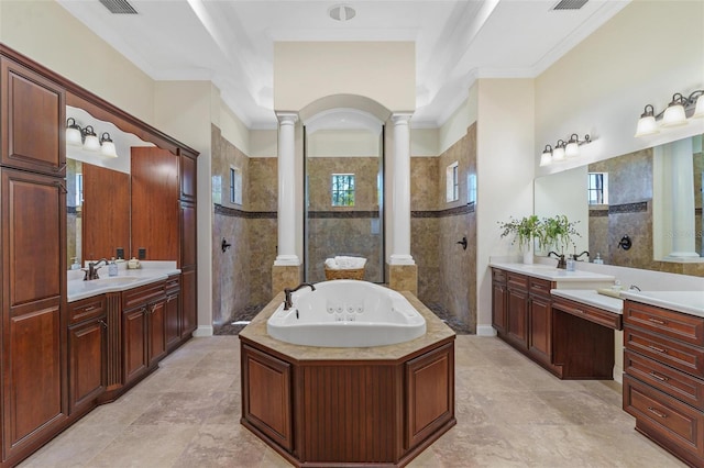 bathroom featuring a walk in shower, a garden tub, two vanities, ornate columns, and a sink