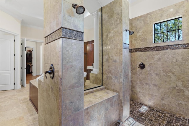 bathroom featuring ornamental molding, a walk in closet, walk in shower, and decorative columns