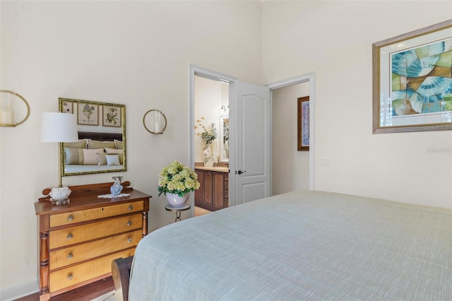 bedroom featuring ensuite bath and wood finished floors