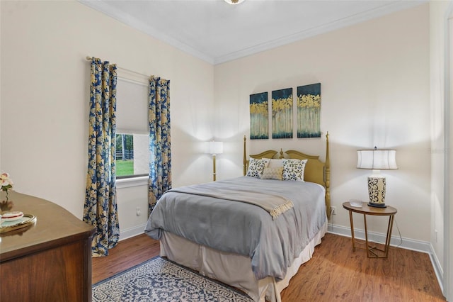 bedroom with crown molding, baseboards, and wood finished floors