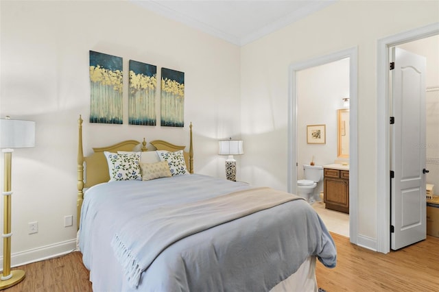 bedroom featuring ensuite bath, crown molding, baseboards, and light wood finished floors