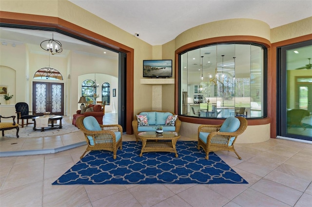 living area with tile patterned floors, french doors, and an inviting chandelier