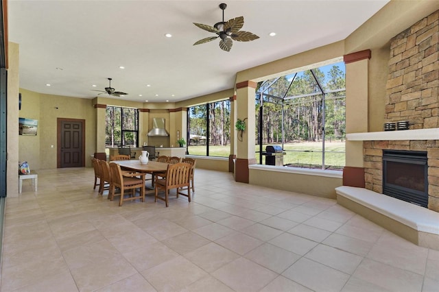 dining space featuring recessed lighting, a fireplace, a ceiling fan, and a sunroom