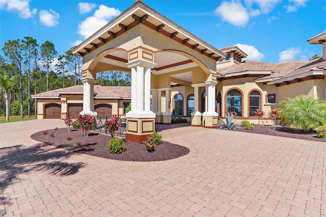 exterior space with stucco siding, an attached garage, and curved driveway