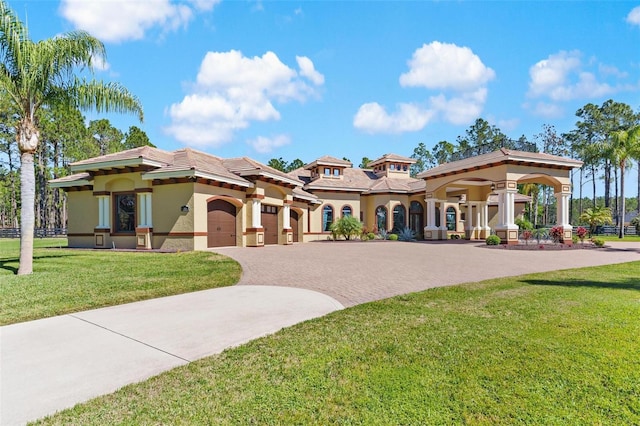 view of front of home with stucco siding, a front lawn, decorative driveway, and a garage