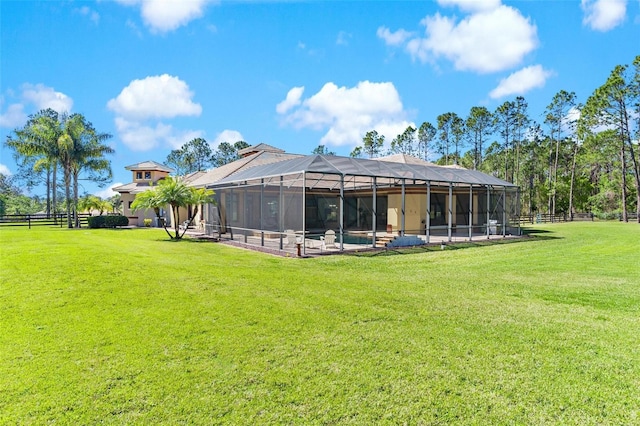 back of house featuring a lanai, a yard, and fence