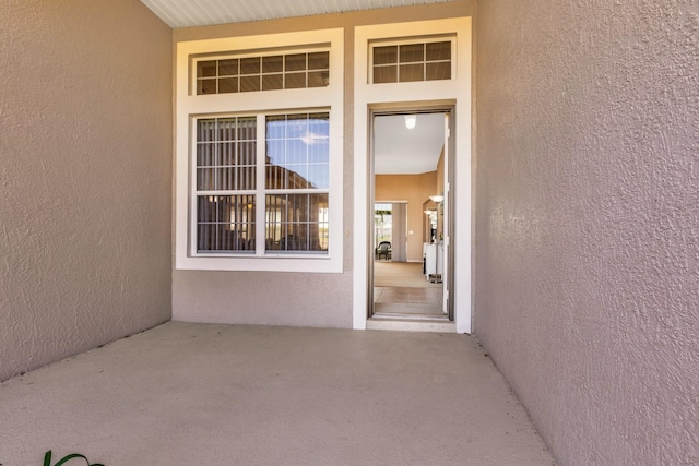 doorway to property featuring stucco siding