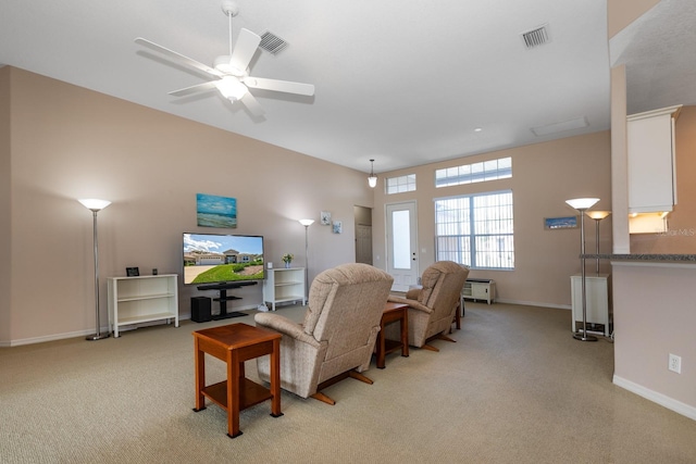 living area with light carpet, baseboards, and visible vents