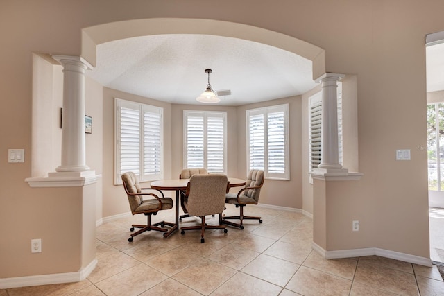 dining room featuring a wealth of natural light and ornate columns